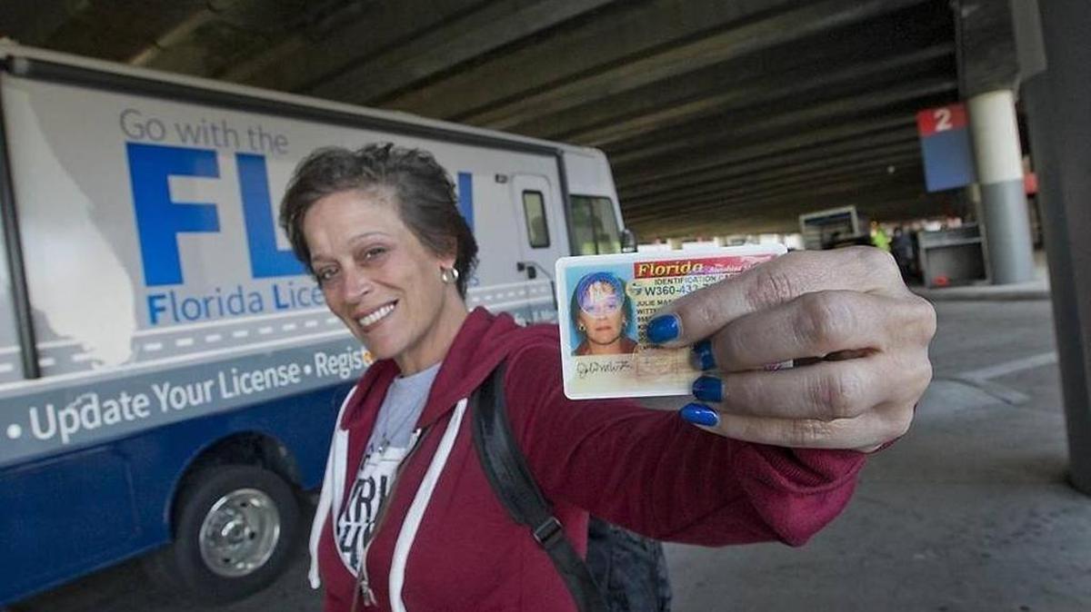 Julie Witter of St. George, Va., gets a temporary Florida ID card from the Florida Licensing on Wheels van at Fort Lauderdale-Hollywood International Airport on Sunday. Witter left some of her belongings behind in the melee caused by the shooting at the airport on Friday.