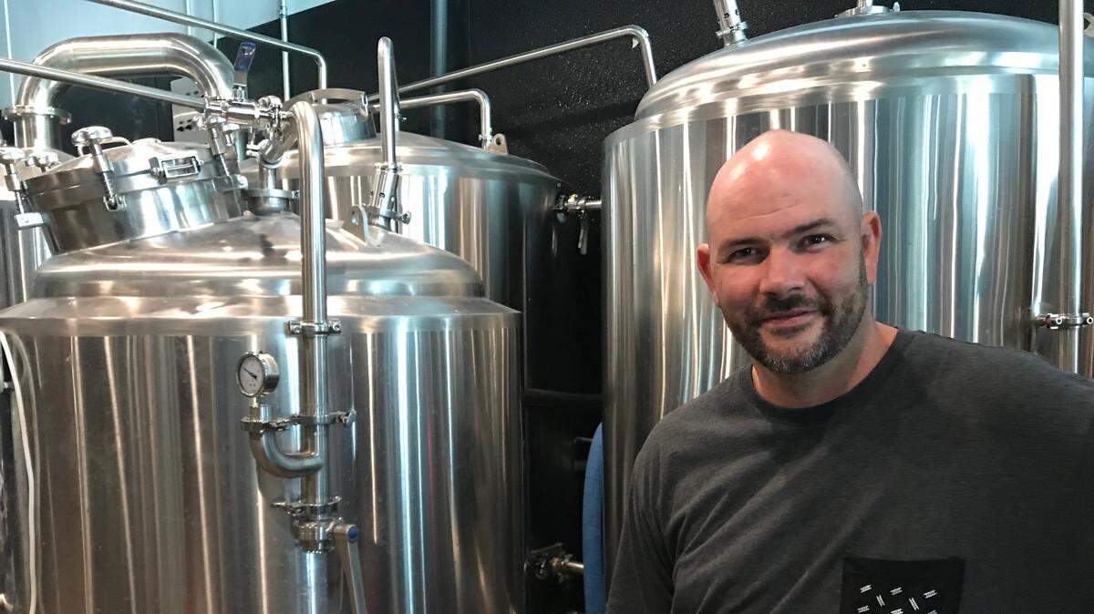 Blake Kleppe of Corporate Ladder Brewing Company, 4935 96th St. E., Palmetto, stands next to a bank of fermenters. The company recently marked its first year of business.