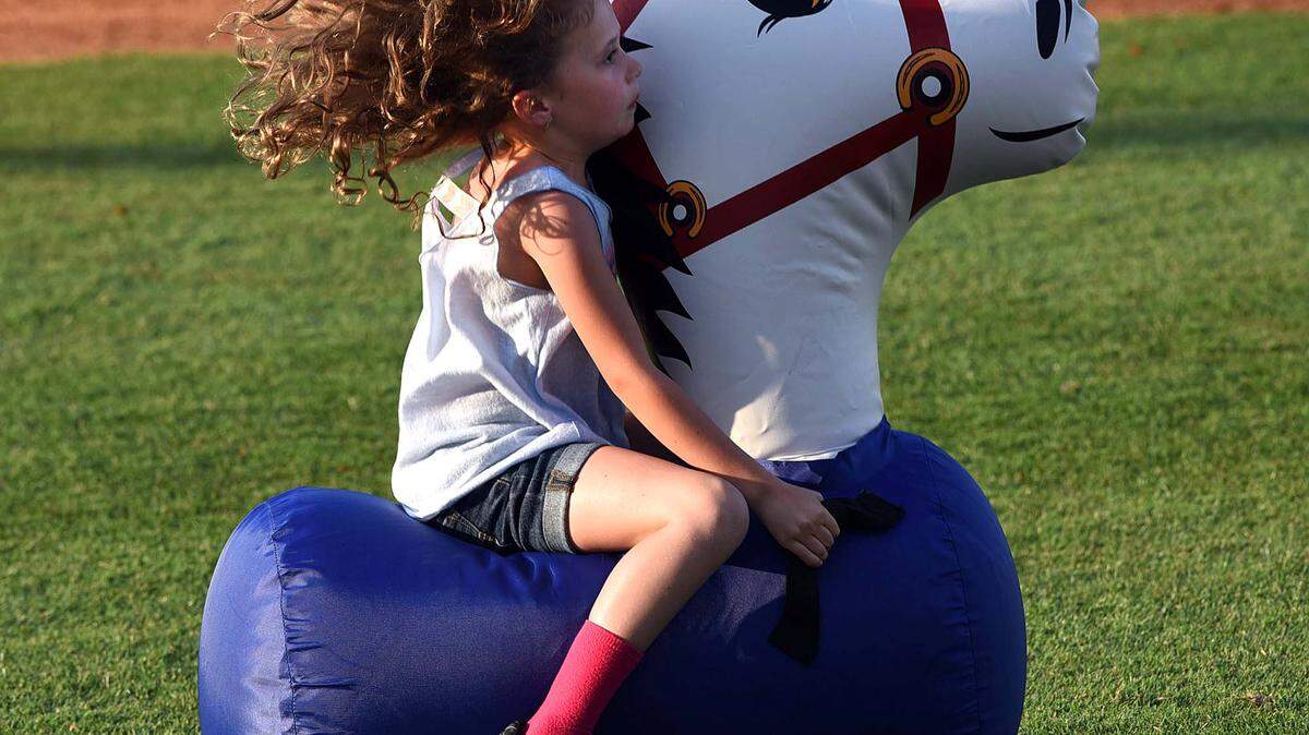 A young girl's hair flies as she participates in a race during a Marauders game at McKechnie Field Thursday. 
 TIFFANY TOMPKINS/Bradenton Herald