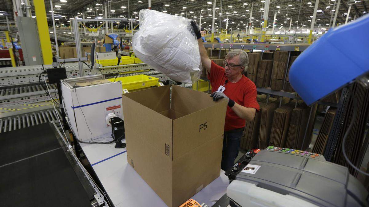 Mark Oldenburg packs a pair of pillows into a box for shipment to a customer, Monday, Nov. 30, 2015, at Amazon.com's fulfillment center in DuPont, Wash. Shoppers went online Monday to snap up "Cyber Monday" deals and the day was expected to be the biggest online shopping day ever. (AP Photo/Ted S. Warren)