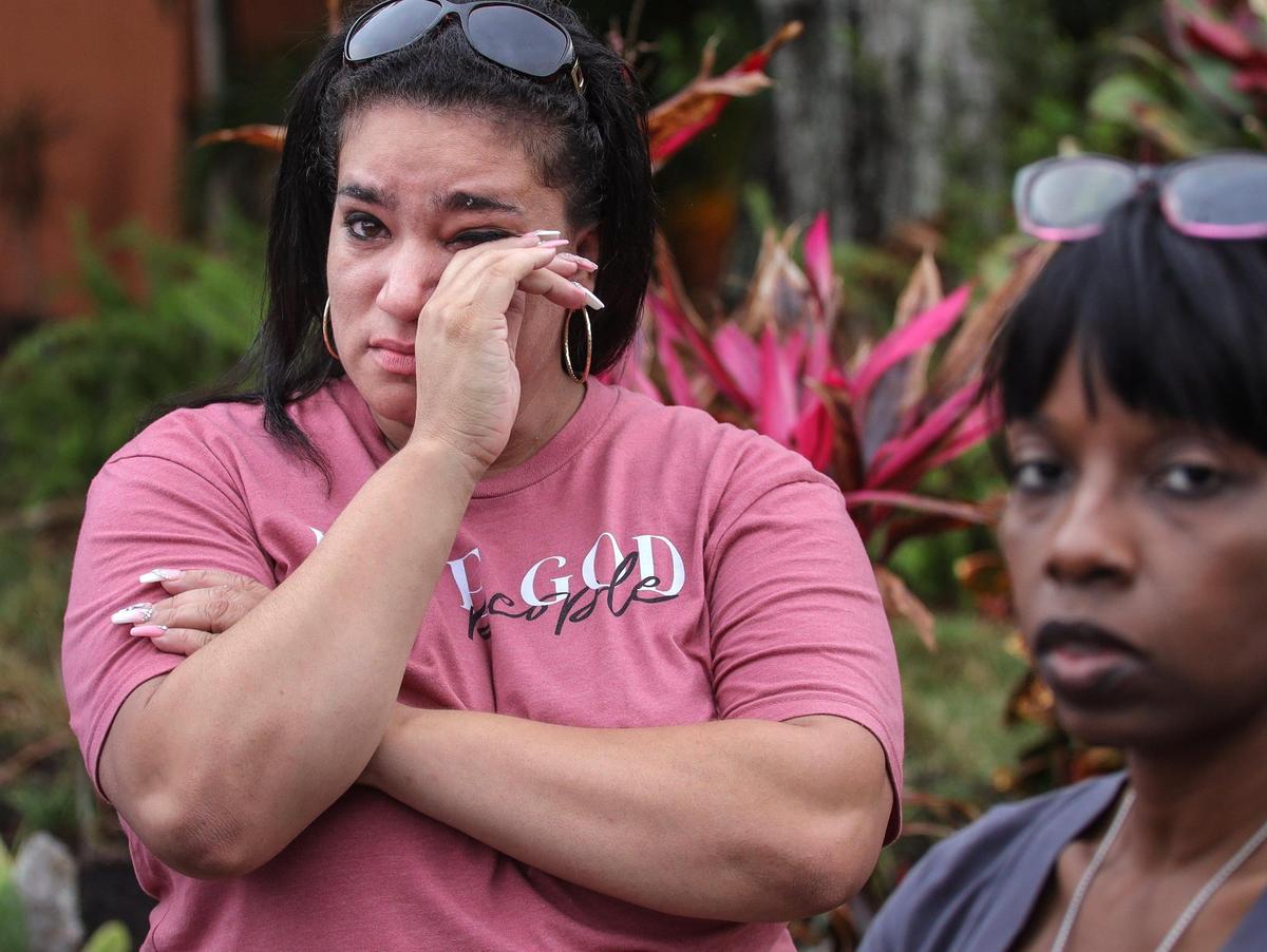Evicted former public housing resident Nairobys Toledo, left, wipes back tears after she and a group of tenants confronted Jason Kraft, a resident commissioner of the Housing Authority Board, outside his home.