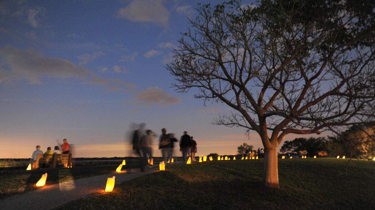 Luminaries cast a faint glow as visitors walk the trails Saturday evening at De Soto National Memorial during the fourth annual Winter Luminary Walk. 
 GRANT JEFFERIES/Bradenton Herald