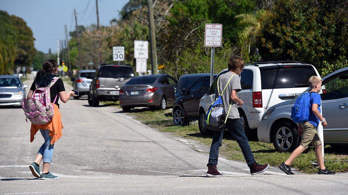 King Middle School students head toward a line of cars parked along a side street near the school where parents pick up their children. A council of governments meeting will discuss parking and traffic issues in the area.TIFFANY TOMPKINS/Bradenton Herald
