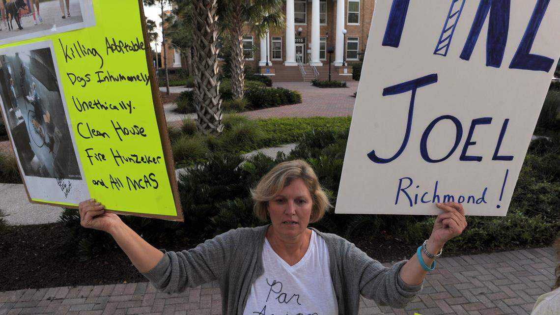 Animal advocate Angela Yoho gathers with others Thursday along Manatee Avenue West, across from the County Administration Building, to protest Manatee County's treatment of animals, and demanded the removal of Manatee County Administrator Ed Hunzeker, Manatee County Animal Services interim chief Joel Richmond and others at the agency. 
 GRANT JEFFERIES/Bradenton Herald
