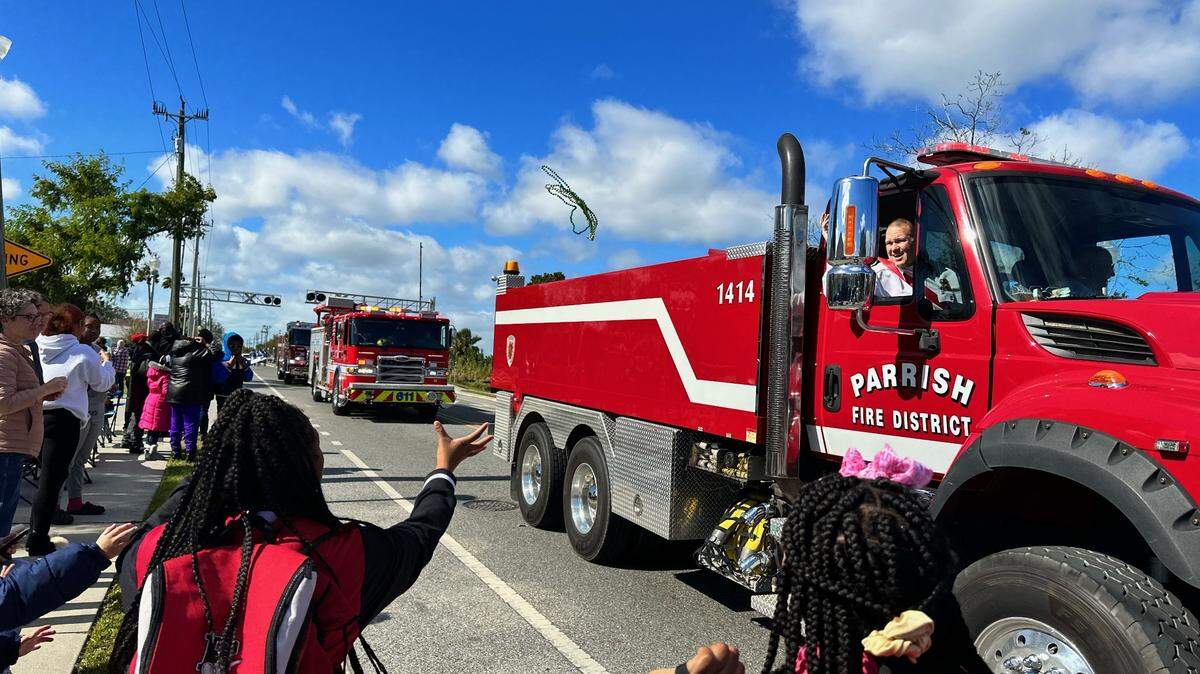 On Saturday, Jan. 14, 2023, the Dr. Martin Luther King Jr. Parade returned to Palmetto. A student reaches for beads as a Parrish Fire Department engine passes by.