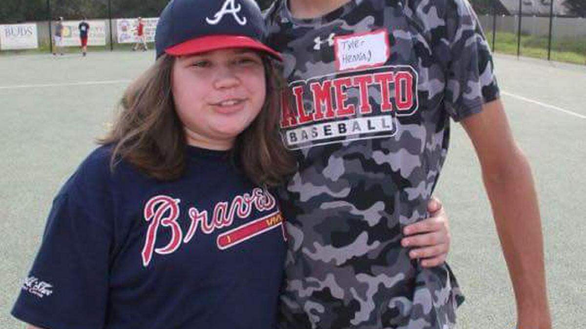 Tyler Henning of Palmetto High School was partnered with Madeline, a 10-year-old girl with autism. They got to hit, throw and run the bases. 
 PHOTO PROVIDED