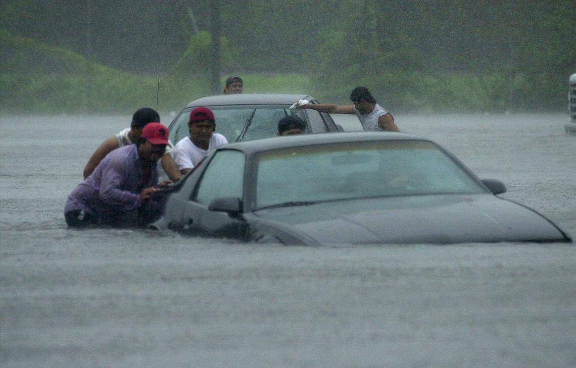 In this 2001 file photo, residents push cars through flooded streets as they are evacuated from the Oakridge Apartments in Palmetto. The area was flooded as Tropical Storm Gabrielle moved across Manatee County.