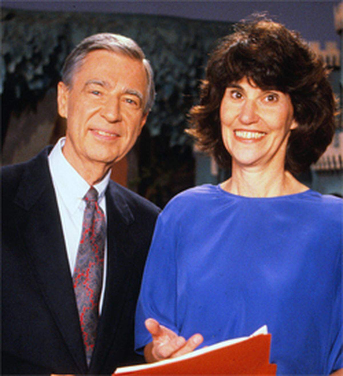 Fred Rogers, the host of Mister Rogers’ Neighborhood, stands alongside Hedda Sharapan, who started as the show’s assistant director before going on to share Rogers’ legacy after his passing. 