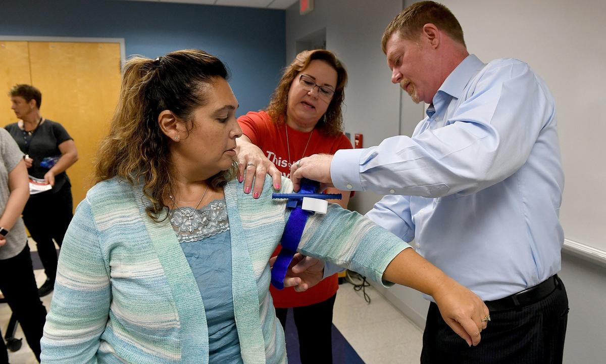 Lisa Goss and Todd Fritch learn how to correctly apply a tourniquet with Cindy Tanner, center, in a class called “Stop the Bleed.” The class was designed as a response to a growing number of mass shootings, the American College of Surgeons developed a program that teaches school employees and students how to prevent someone from bleeding to death.