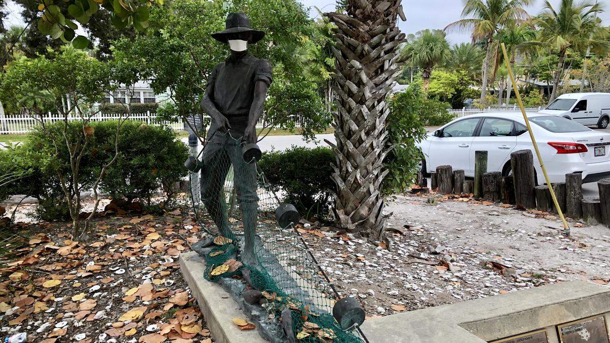 The memorial to commercial fishermen in Cortez wears a face mask in recognition of the coronavirus pandemic.