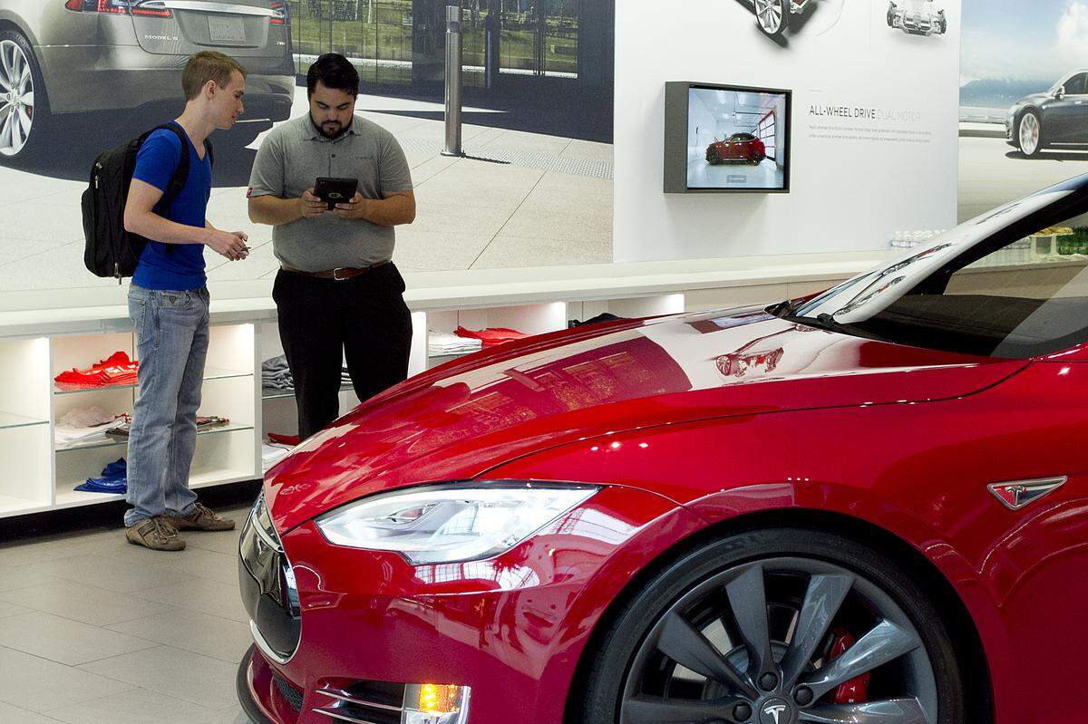 A customer puts down a reservation for a Tesla Model 3 in 2016 at The Mall at University Town Center.