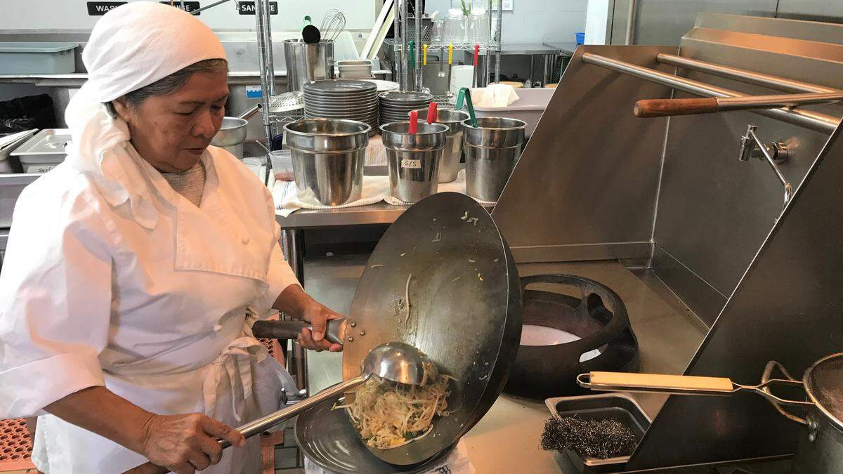 Grisna Cochran scoops Pad Thai from the wok onto a plate at Thai Cafe, 4511 Manatee Ave.