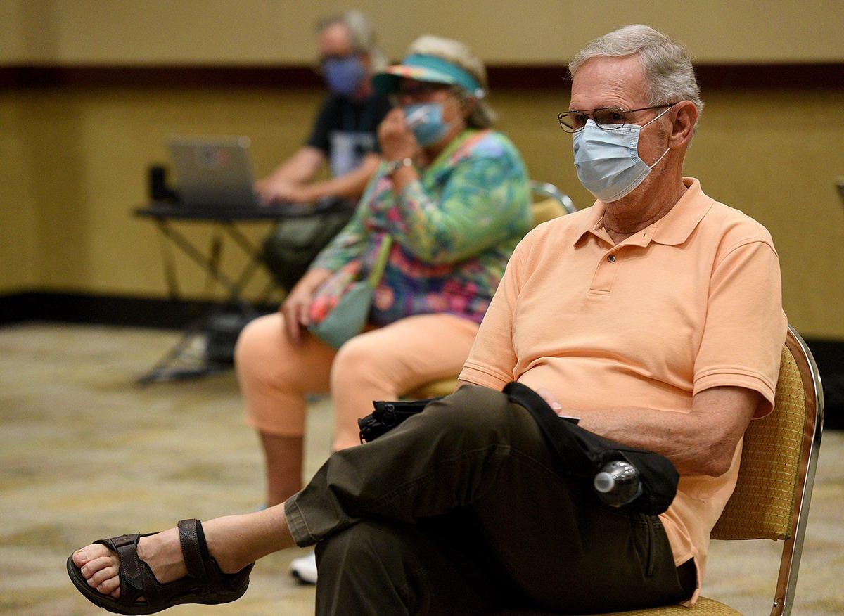 Members of the public, some wearing masks and some not wearing them, listen as members of the Manatee County Commission gather at the Bradenton Area Convention Center to decide upon a mask wearing resolution.