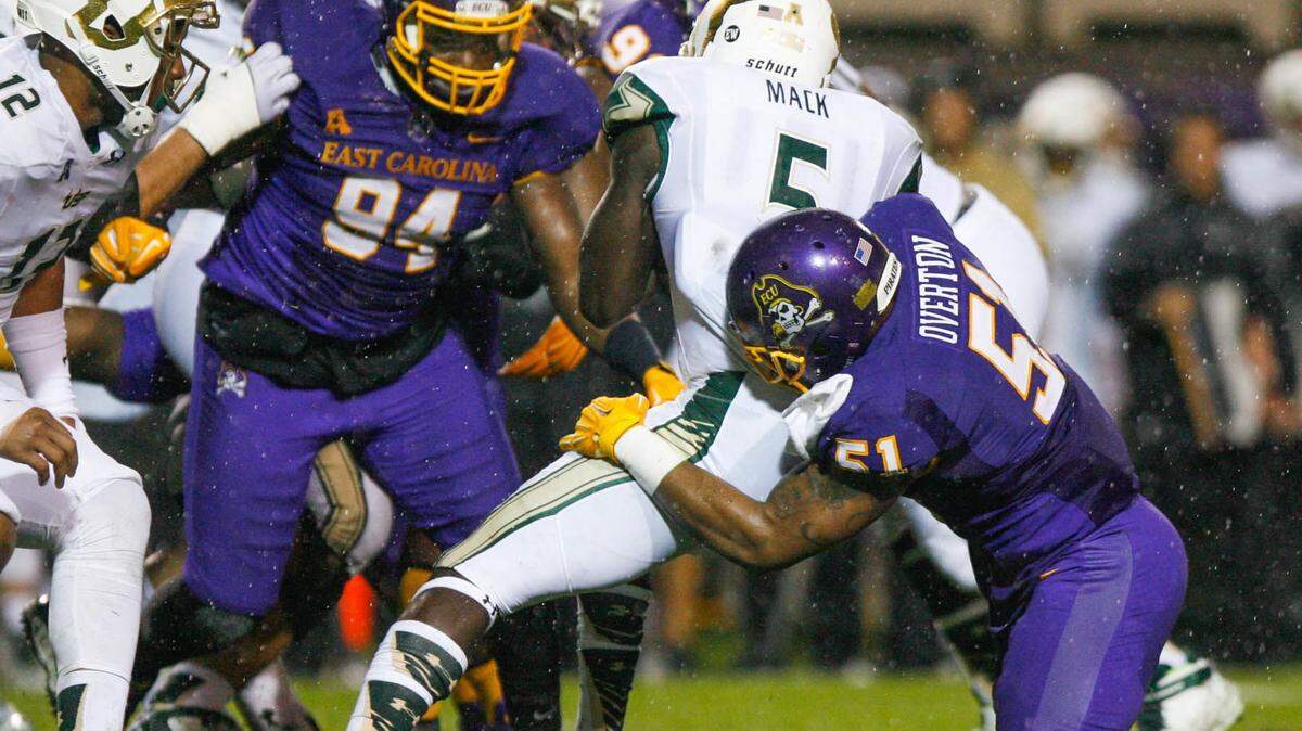 South Florida's Marlon Mack is tackled by East Carolina's Montese Overton during the first half of an NCAA football game in Greenville, N.C., on Saturday, Nov. 7, 2015. (Bayardo Caceres-Rossel/The Daily Reflector via AP)