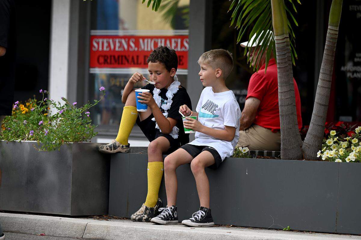 Two boys enjoy a treat at the block party before the DeSoto Parade on Saturday, April 27, 2024.