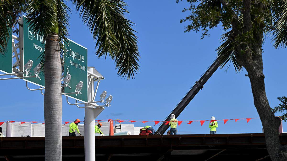 Construction workers atop the the roof of the new terminal under construction at Sarasota Bradenton International Airport, Sept. 25, 2023.
