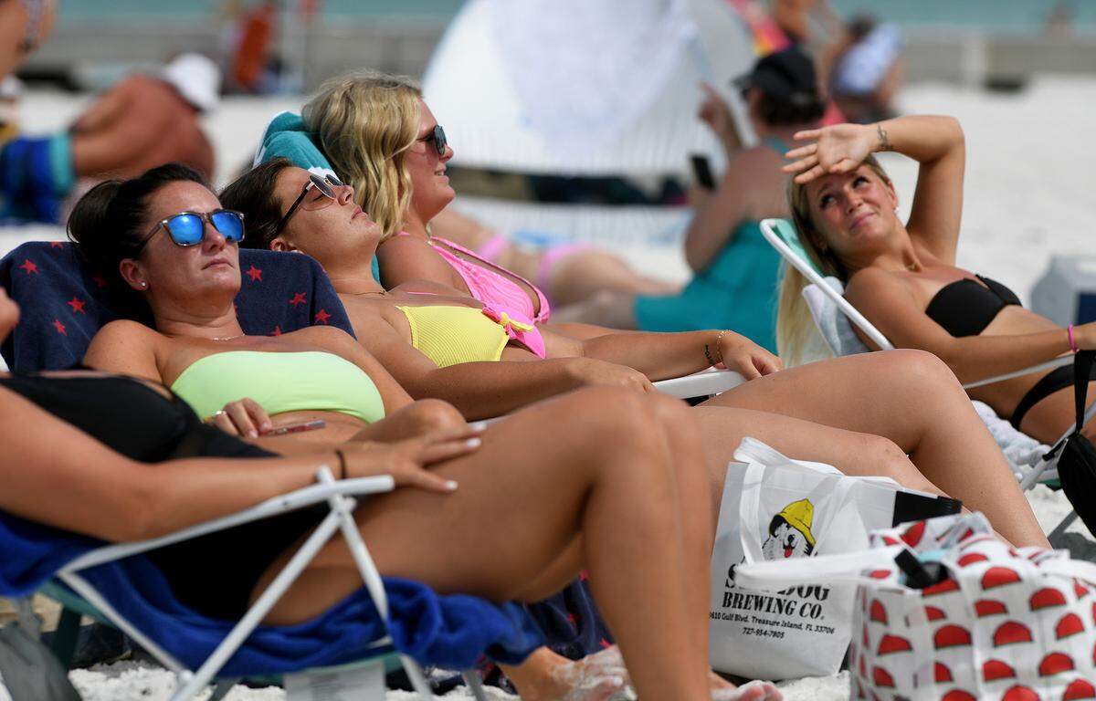 Visitors from Kansas enjoy the weather before rain bands from a tropical disturbance make their way to Manatee County beaches Friday. The National Hurricane Center is forecasting the system to slightly strengthen into a tropical storm.