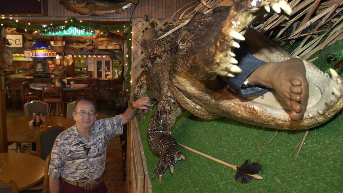 Frank Gamsky, beside a 12 foot 2 inch allagator on display in the dining room at Linger Lodge in east Manatee County. Photo Jefferies 6-12-02