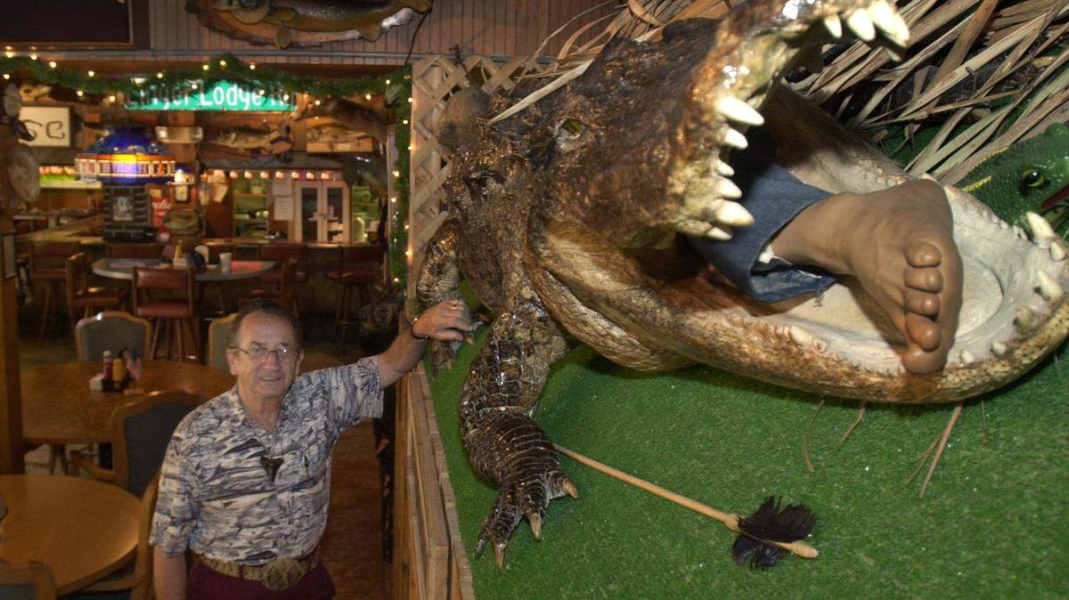 Frank Gamsky, beside a 12 foot 2 inch allagator on display in the dining room at Linger Lodge in east Manatee County. Photo Jefferies 6-12-02