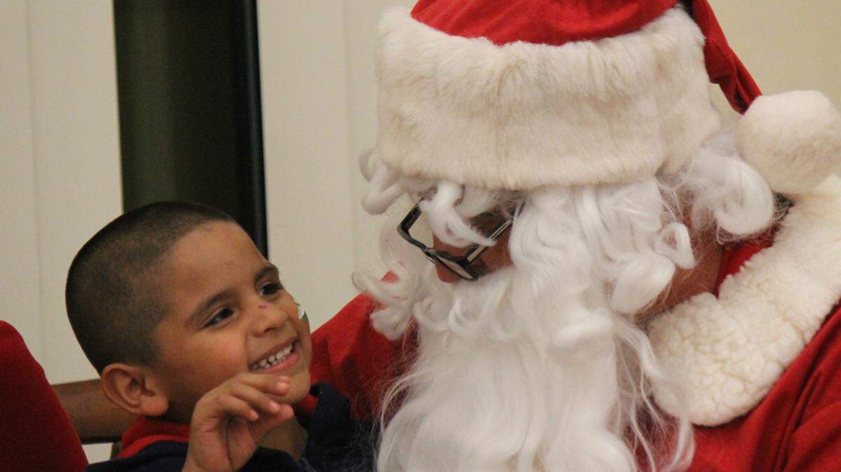 Santa Claus visits with a little boy Thursday night at the Parrish Childrens Christmas Party.JAMES A. JONES JR./Bradenton Herald