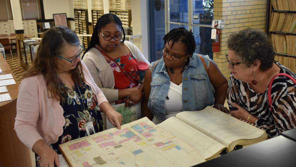 The Historical Records Library in Manatee County is planning to begin quarterly workshops that allow residents to work with staff to explore records related to genealogy and local history. The sessions are designed to accommodate guests who cannot visit the archives during weekday operations. Director Cathy Slusser (left) explains how to read Sanborn fire insurance maps.