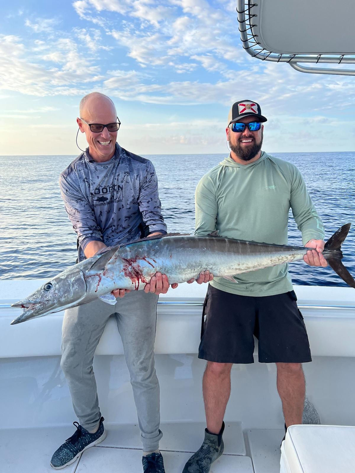 Fisherman Jason Lockhard (right) and “Capt. E” (left) pose for a photo with a wahoo caught in the Gulf of Mexico.