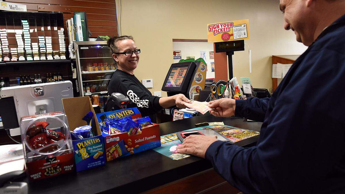 Lenny Gillespie buys some PowerBall tickets Tuesday afternoon from Lou Thomey. Lottery retailers in the area have seen large increases in lottery ticket sales since the Powerball hit $800 million last week and has now increased to $1.5 billion. Co-owner of Market on Main Lou Thomey said she's sold ten times more lottery tickets than usual in the past week or so. 
 TIFFANY TOMPKINS-CONDIE/Bradenton Herald