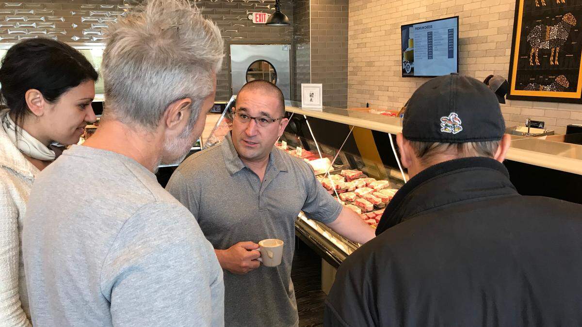 Charlie Haney shows guest around Butcher’s Mark at 8519 Cooper Creek Blvd. Wednesday was grand opening day for the new meat market.