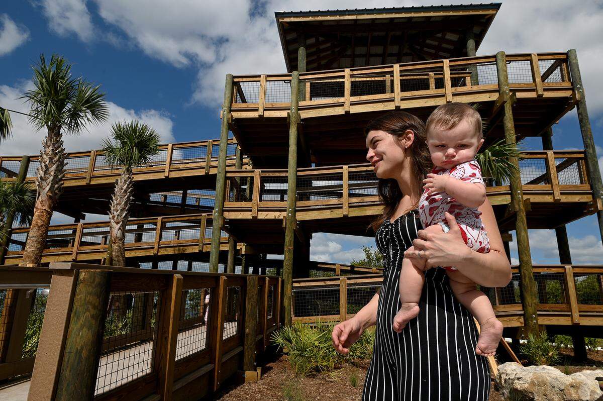 Kristina Rhinehart with 7-month-old Nyomi waits for her 3-year-old to come down from the newly-finished, ADA-compliant tower along the eastern portion of Bradenton’s Riverwalk.