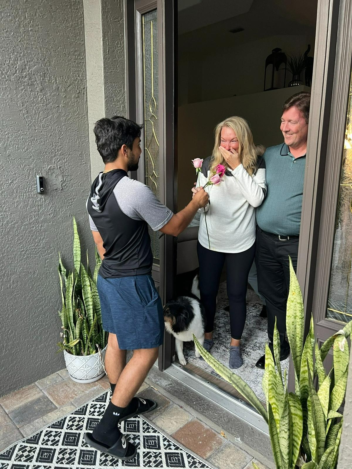 Christine Orlander holds a hand over her mouth in surprise as she has been given pink roses by a member of the Lakewood Ranch High School varsity baseball team on March 3, 2022. She recently had double mastectomy surgery and has been recovering at her Lakewood Ranch home.