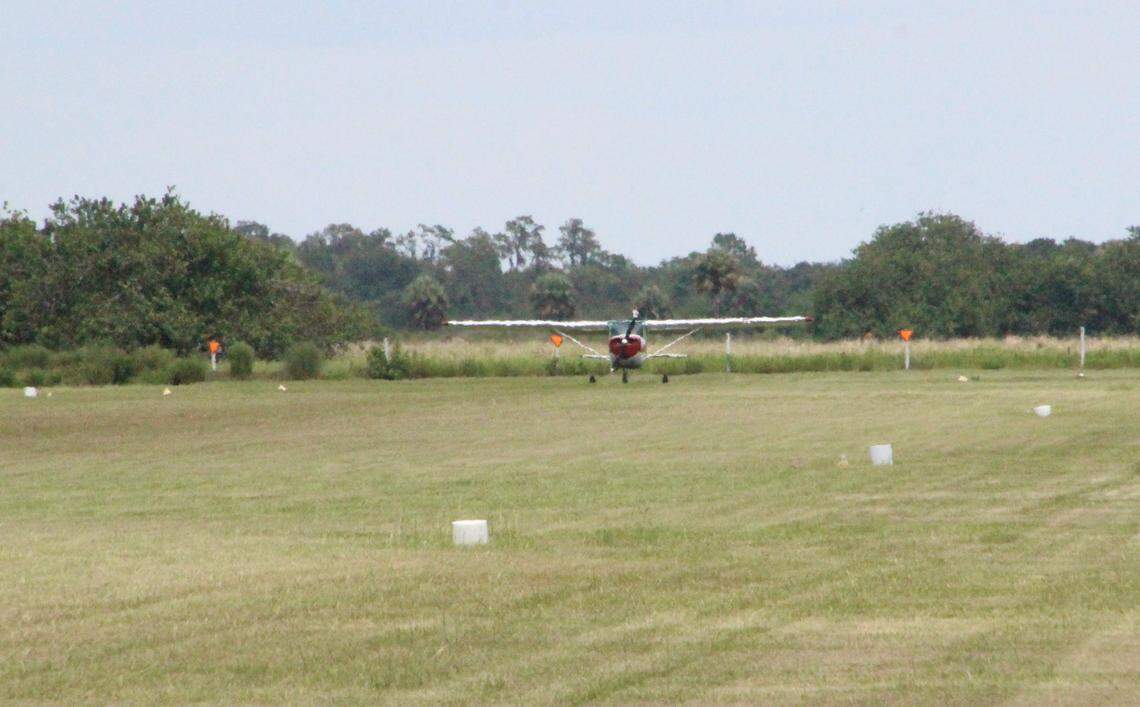 An airplane gathers speed as it prepares to takeoff from the grass runway at Airport Manatee.
