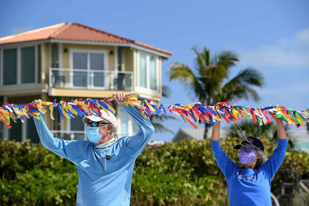 02/16/21--Richard and Joanne Brown of Holmes Beach joined a group of people led by Cathy Tobias hold a memorial created from ribbons and stretching 250 yards to remember the almost 27,000 people lost to COVID-19 in Florida.