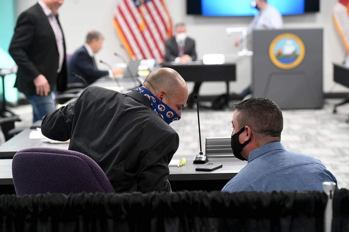 02/18/21--Bryan Kitchner, a special agent with the FDLE served subpoenas to four commissioners ahead of ThursdayÕs public work session meeting. Commissioner, Kevin Van Ostenbridge, left, talks with the agent while receiving the subpoena.
