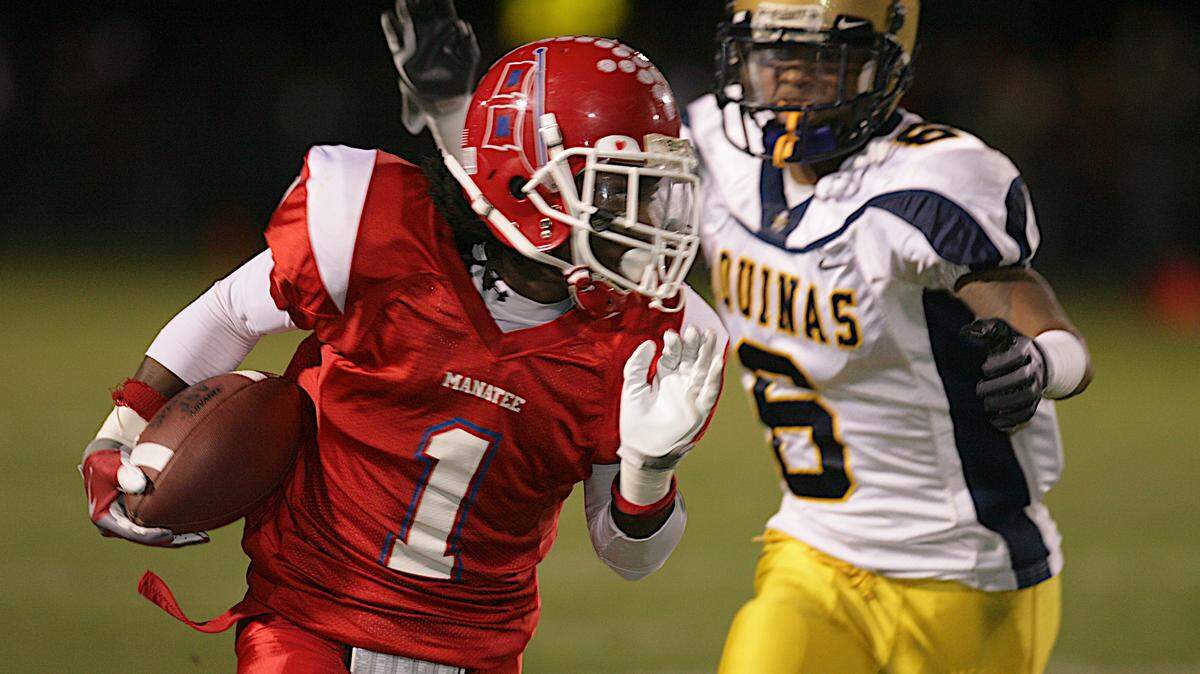PAUL VIDELA/pvidela@bradenton.com 
 Manatee High School wide receiver Tracy Sanders, at left, heads for the sideline while eluding St. Thomas Aquinas' Marcus Roberson during the Class 5A State Semifinal football game at Manatee High School in Bradenton, FL.