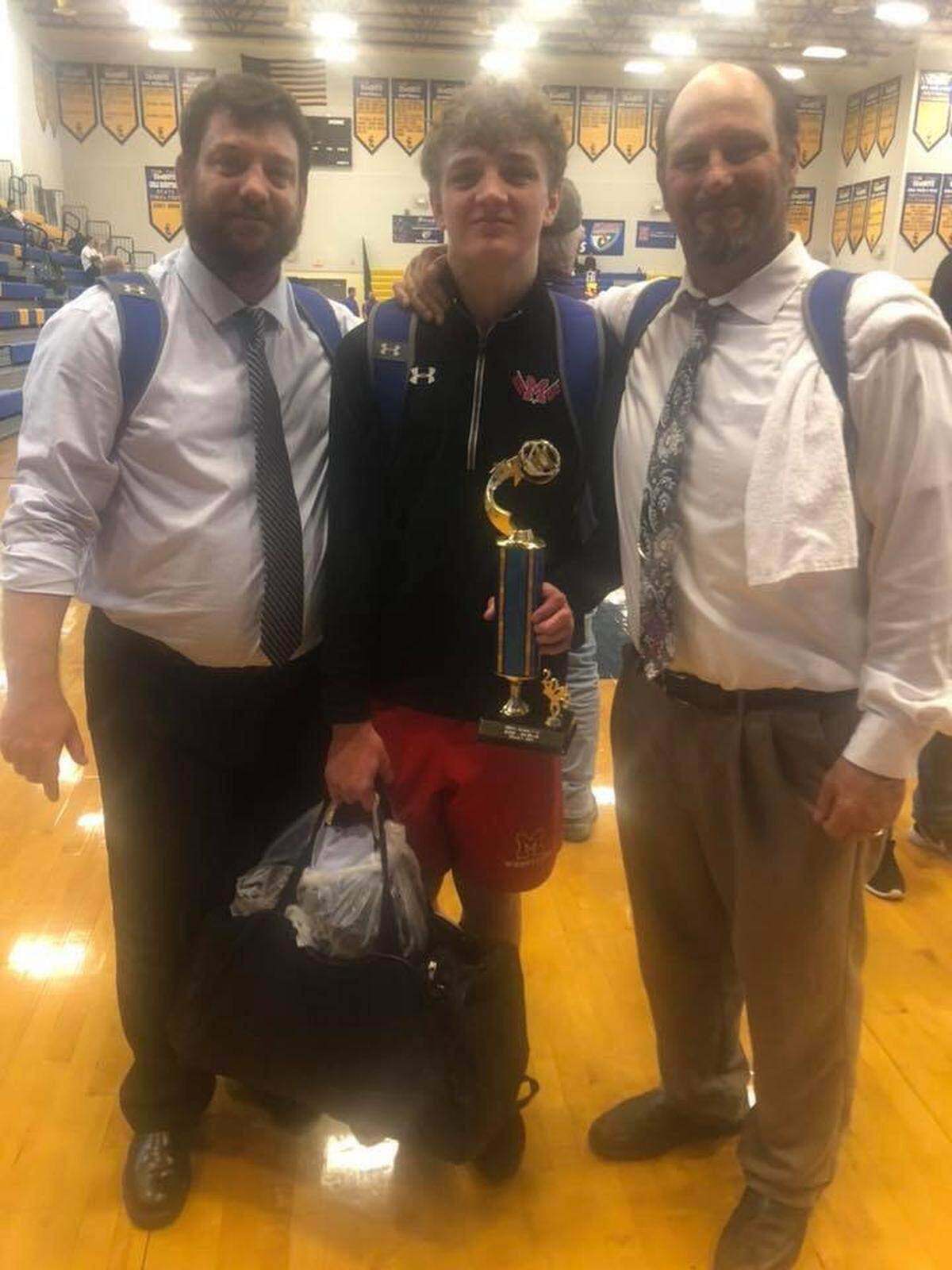 Manatee High sophomore wrestler Tylynn Lukens with his father Dan, left, and Hurricanes coach Andrew Gugliemini.