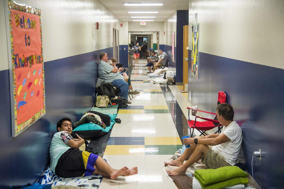 Evacuees rested in makeshift camps in the hallway of Bayshore Elementary School as Hurricane Irma approached South Florida in Bradenton. Hurricane shelters should be a last resort as the COVID-19 pandemic is changing the way residents should prepare for hurricanes.