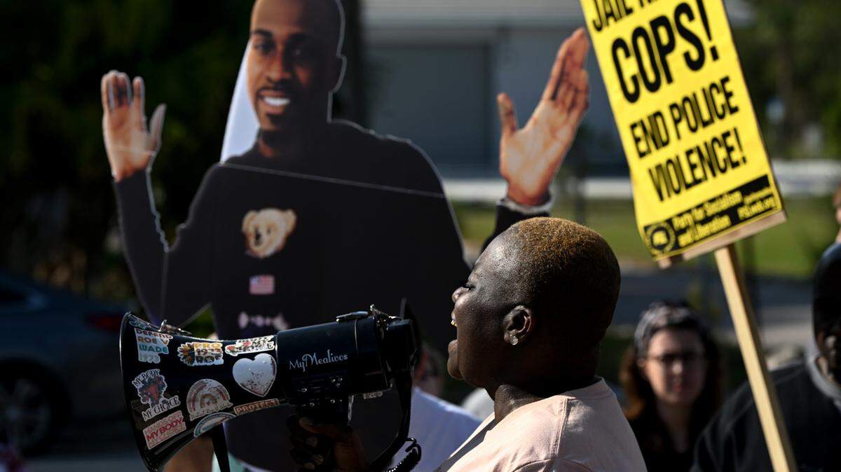 Tracey Washington mourns the death of her son, Breonte Johnson-Davis, beside a life-sized poster image of him Sunday. Dozens of protesters gathered at the Palmetto Police Department on Sunday, Jan. 7, 2024, to demand answers following the November death of 36-year-old Johnson-Davis, who died shortly after Palmetto police officers used a stun gun on him, according to a police report.