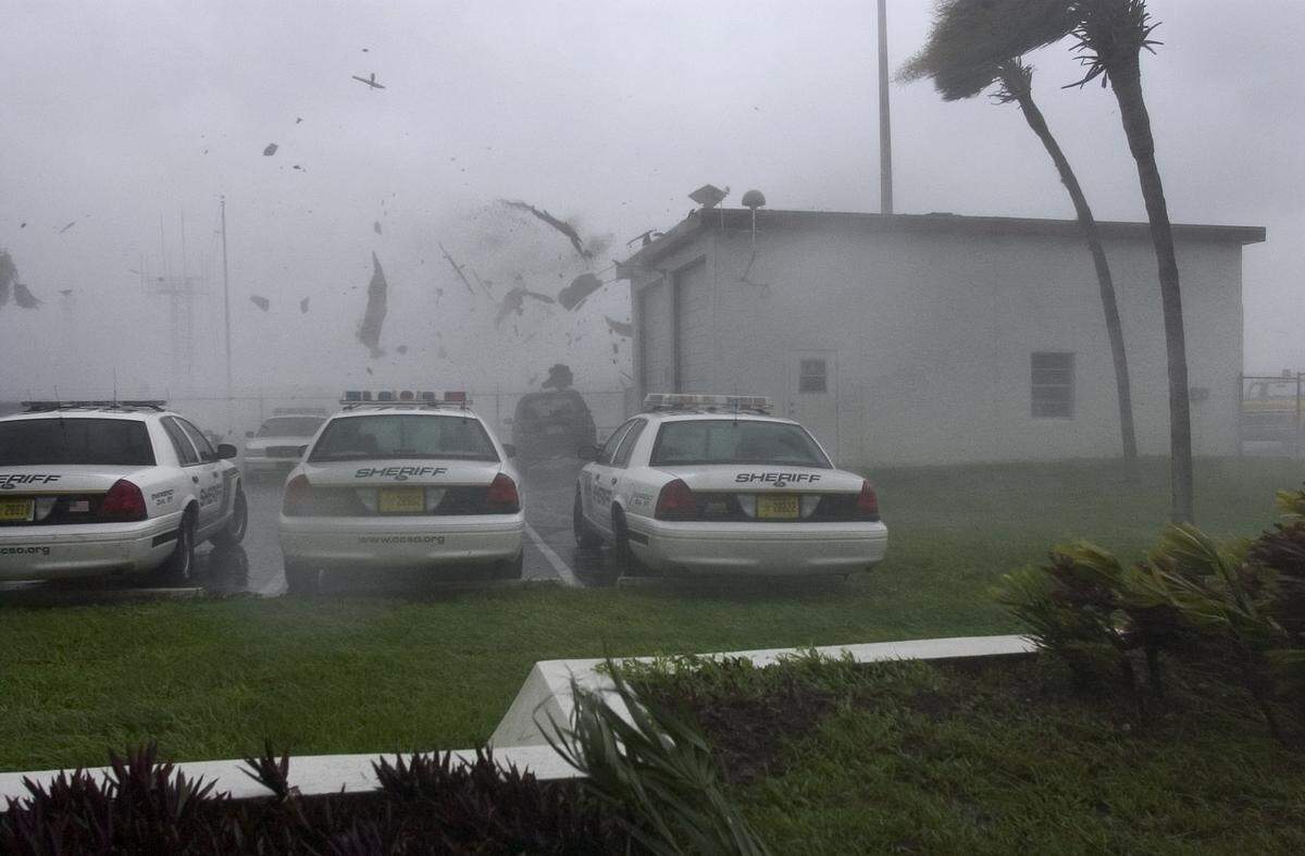 The roof of a garage is blown off onto Charlotte County Sheriff’s cruisers from winds of Hurricane Charley in the parking lot of the Charlotte County Airport, Friday, Aug. 13, 2004, in Punta Gorda,Fla.