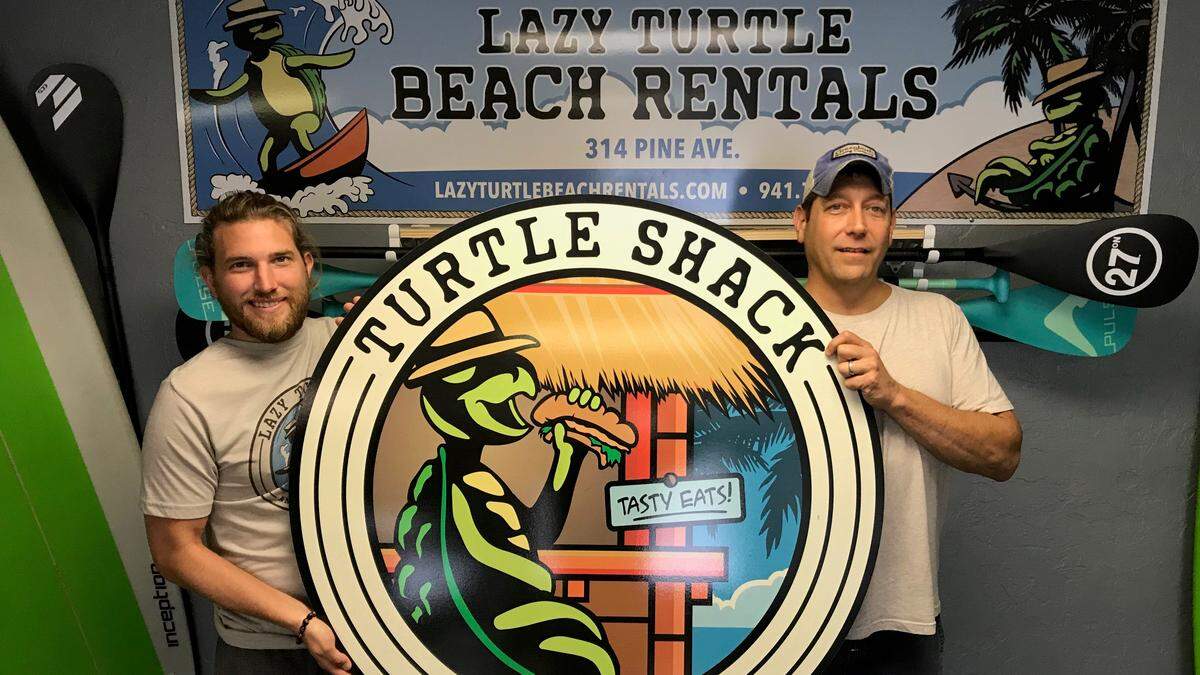 Chase Woolen, left, and Joe Sabath, host the sign for the soon-to-open Turtle Shack at 314 Pine Ave., Anna Maria. An opening in the second week of February is anticipated.
