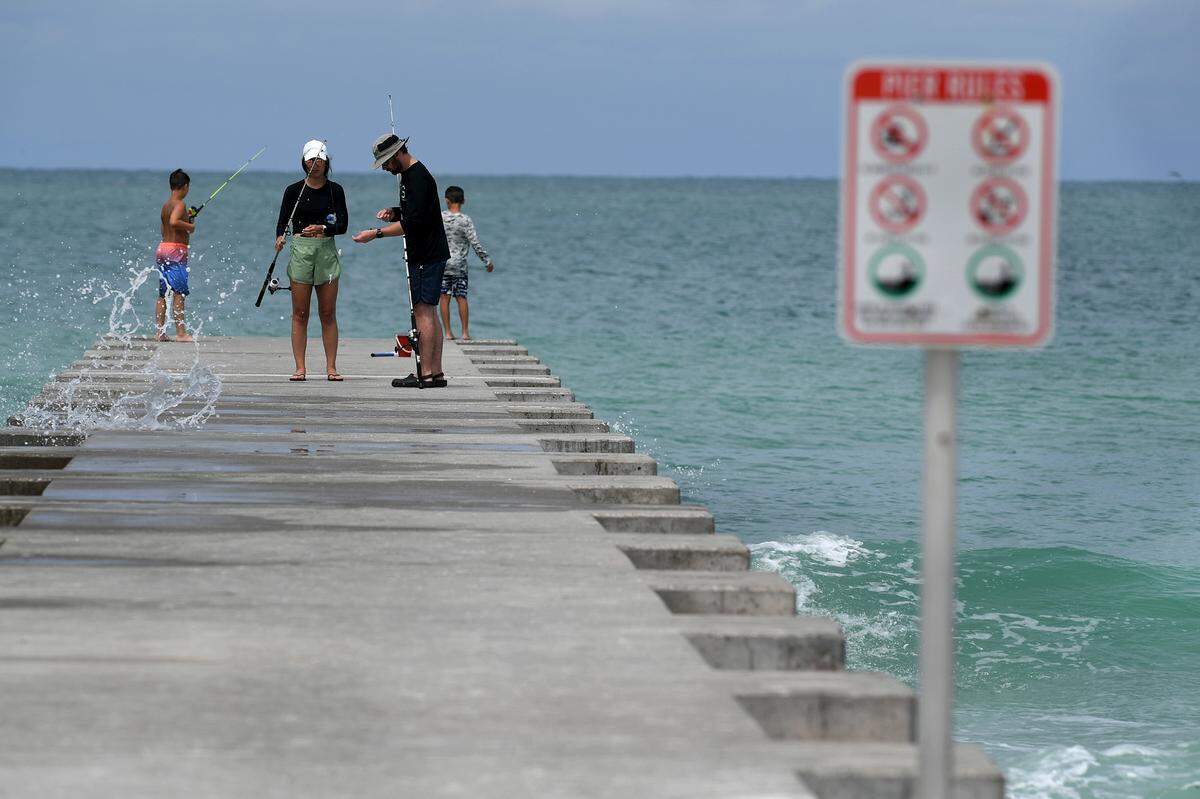 Anglers get a splash from a wave on Cortez Beach Friday. Rain bands from a tropical disturbance impacting South Florida had not made their way to Manatee County beaches mid-morning Friday. The National Hurricane Center is forecasting the system to slightly strengthen into a tropical storm.