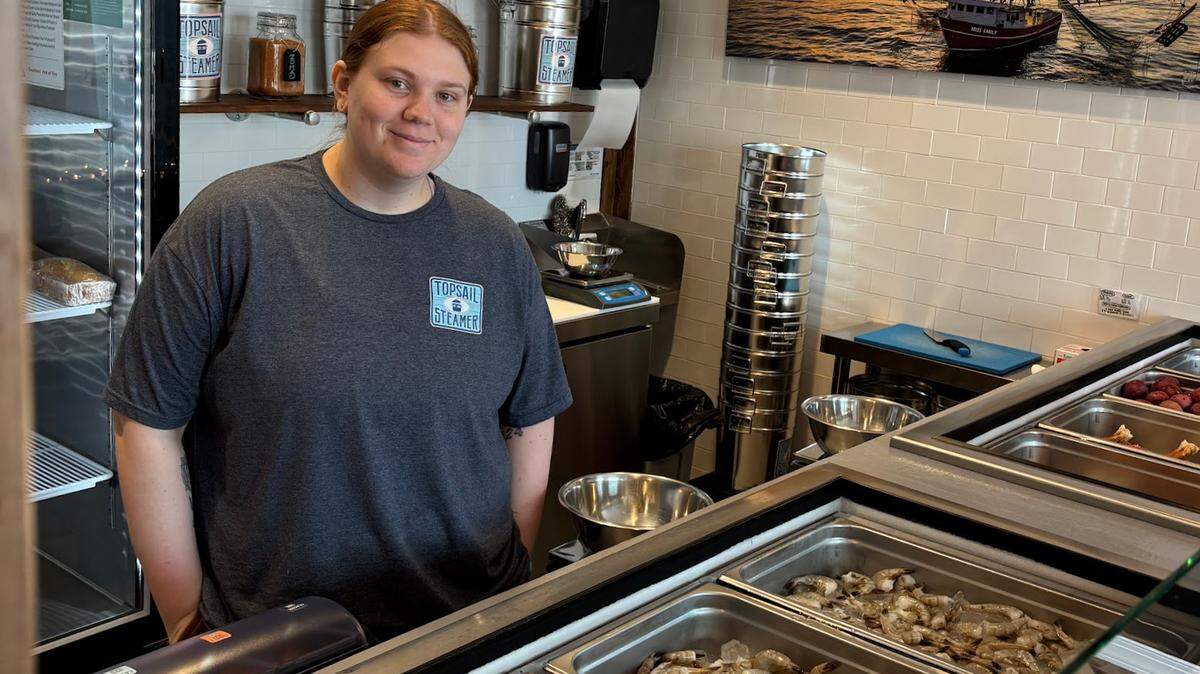 Topsail Steamer employee Alyssa Beard stands behind the seafood line. The restaurant opened at 5321 Gulf Drive, Holmes Beach, in 2023. 