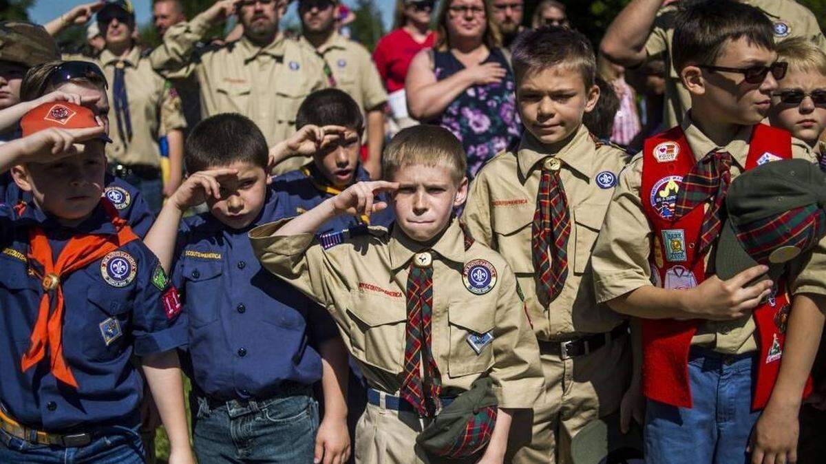 Boy Scouts and Cub Scouts salute during a Memorial Day ceremony in Linden, Mich., last year. On Wednesday, the Boy Scouts of America announced its flagship program will change its name next February to simply be called Scouts BSA as the organization begins to let girls enter the program.