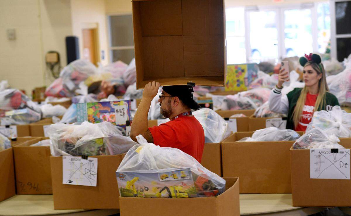 Volunteers gather toys that were collected for 786 families on the Salvation Army’s Angel Tree Distribution Day. Families registered in September to receive presents for their children along with a turkey or ham. The distribution was drive-through style, with dozens working together to make the event run smoothly.