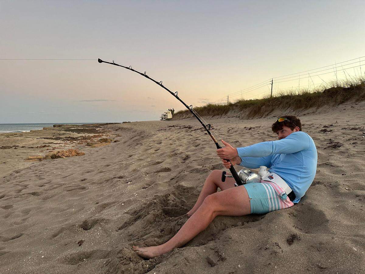 Michael Hengel, 22, of Bradenton fights for a hour to reel in a female bull shark on the sands of North Miami Beach on Feb. 12, 2023.