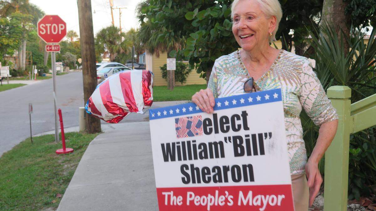 Joyce Kramer, 73, stands with a sign supporting ousted Bradenton Beach Mayor William Shearon on Election Day. 
 AMARIS CASTILLO/Bradenton Herald