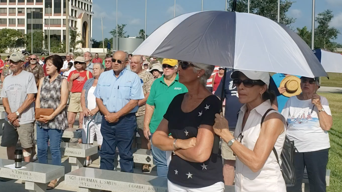 Those gathered at the annual Memorial Day service at Veteran’s Monument Park in Bradenton stand as they listen to a performance of “God Bless America.”