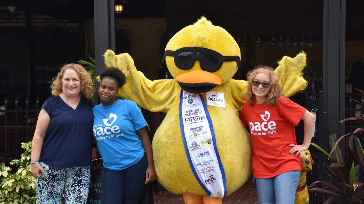 To celebrate the launch of the Round Up For Charity campaign at Mattison’s City Grille on the Bradenton Riverwalk, Caryn Hodge, Mattison’s marketing director (left) poses for a photo with the PACE Center for Girls mascot, Quacky, and two students from the school, Janayzen (second from the left) and Autumn (right). For the next year, customers can round their checks to the nearest dollar to benefit a different organization each month.