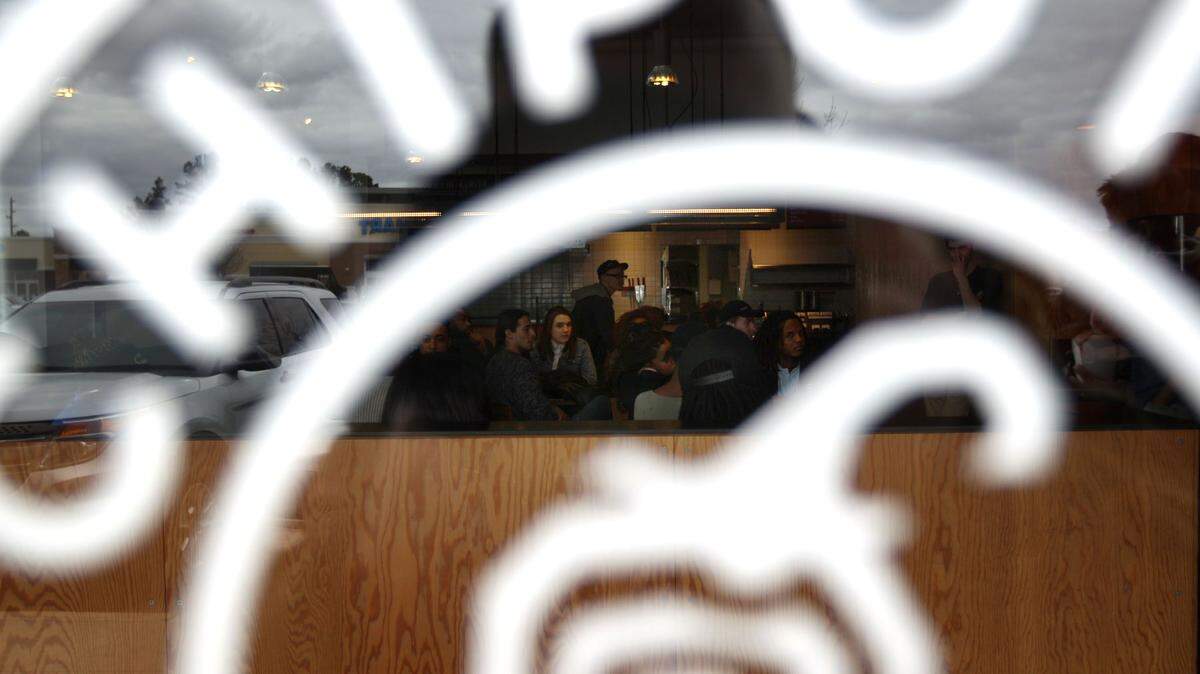Chipotle employees can be seen through locked doors as they attend a meeting inside one of the chain's restaurants, Monday, in East Memphis, Tenn. Chipotle restaurants nationwide opened later than normal on Monday, as employees attended a live broadcast on food safety. 
 MIKE BROWN/The Commercial Appeal