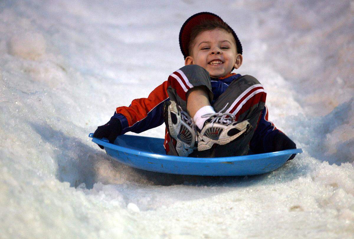Ian Haas, 3, enjoys a toboggan ride on the man-made hill on Old Main Street as part of the 2006 Winter Wonderland festivities. 