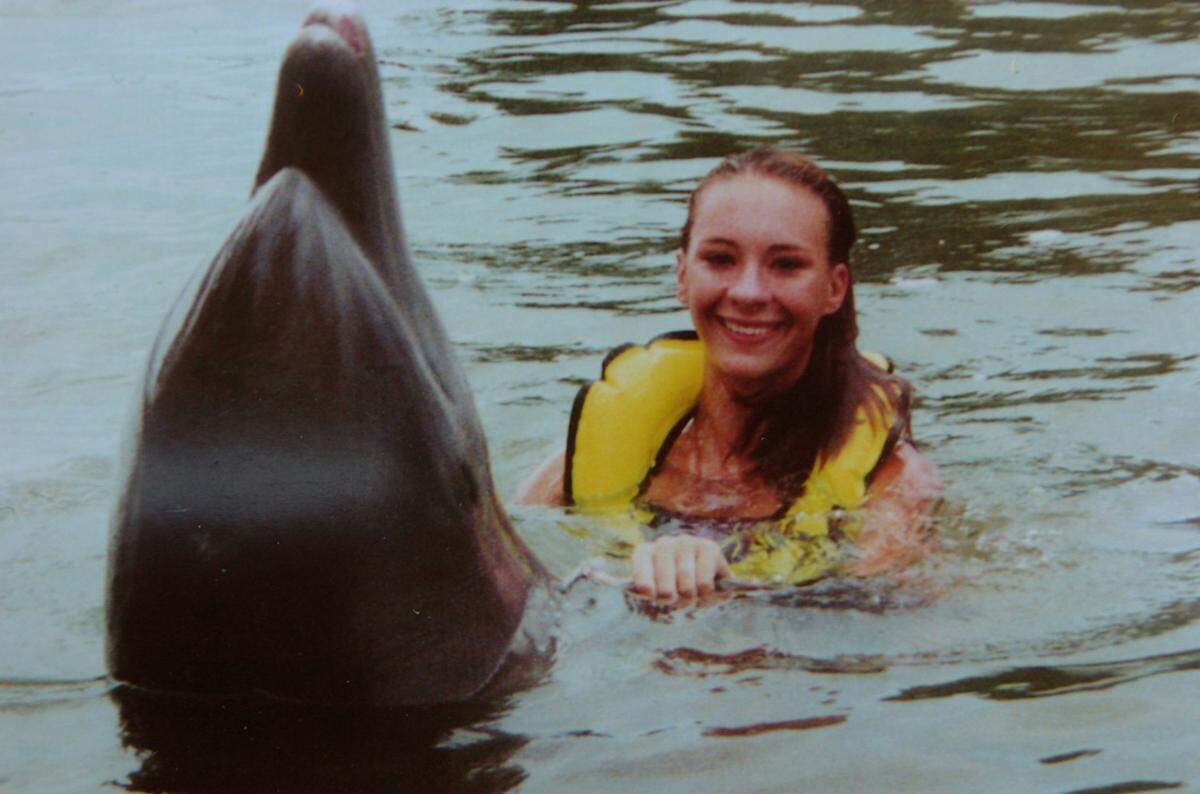Tiffiany Olson is shown swimming with a dolphin. She died in a 2005 motorcycle crash.